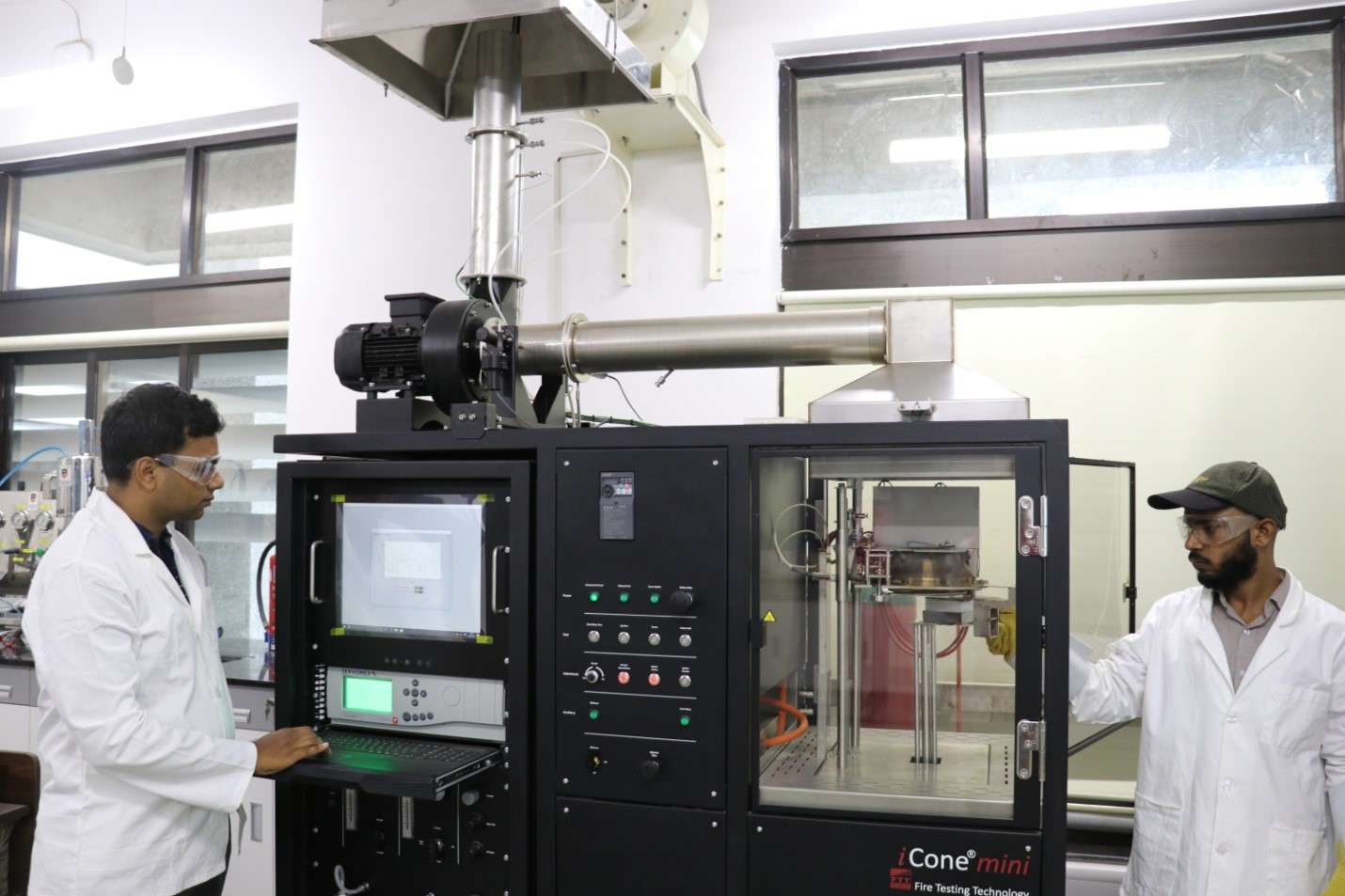 Dr. Gaurav Srivastava and Nasar Ahmad Khan in their laboratory with a Cone Calorimeter, which is used to measure combustion properties of materials